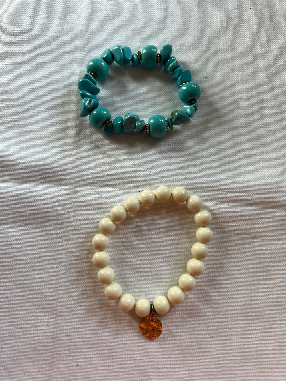 Turquoise bracelet and ivory bracelet.